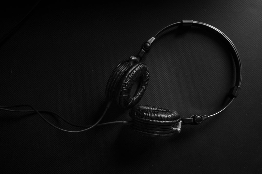Auriculares negros y plateados sobre superficie oscura